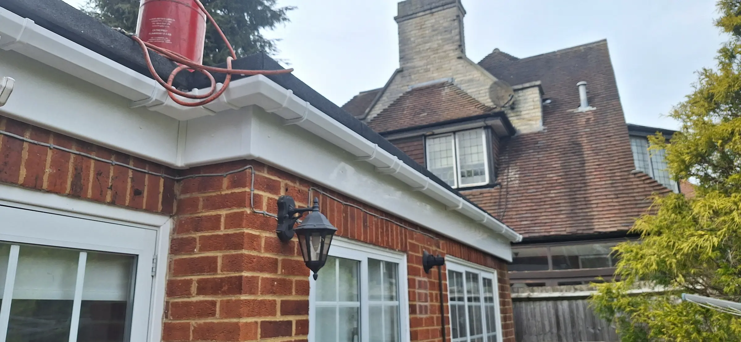 A brick house with a white roof and a lantern.