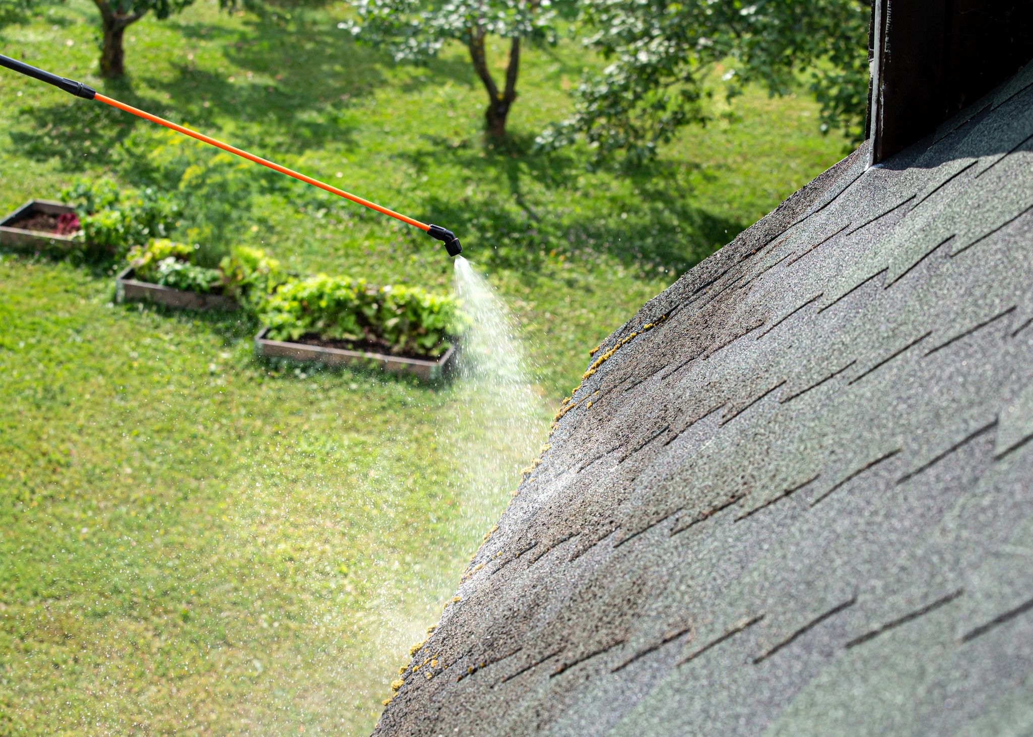 Worker cleaning house gutter from leaves and dirt