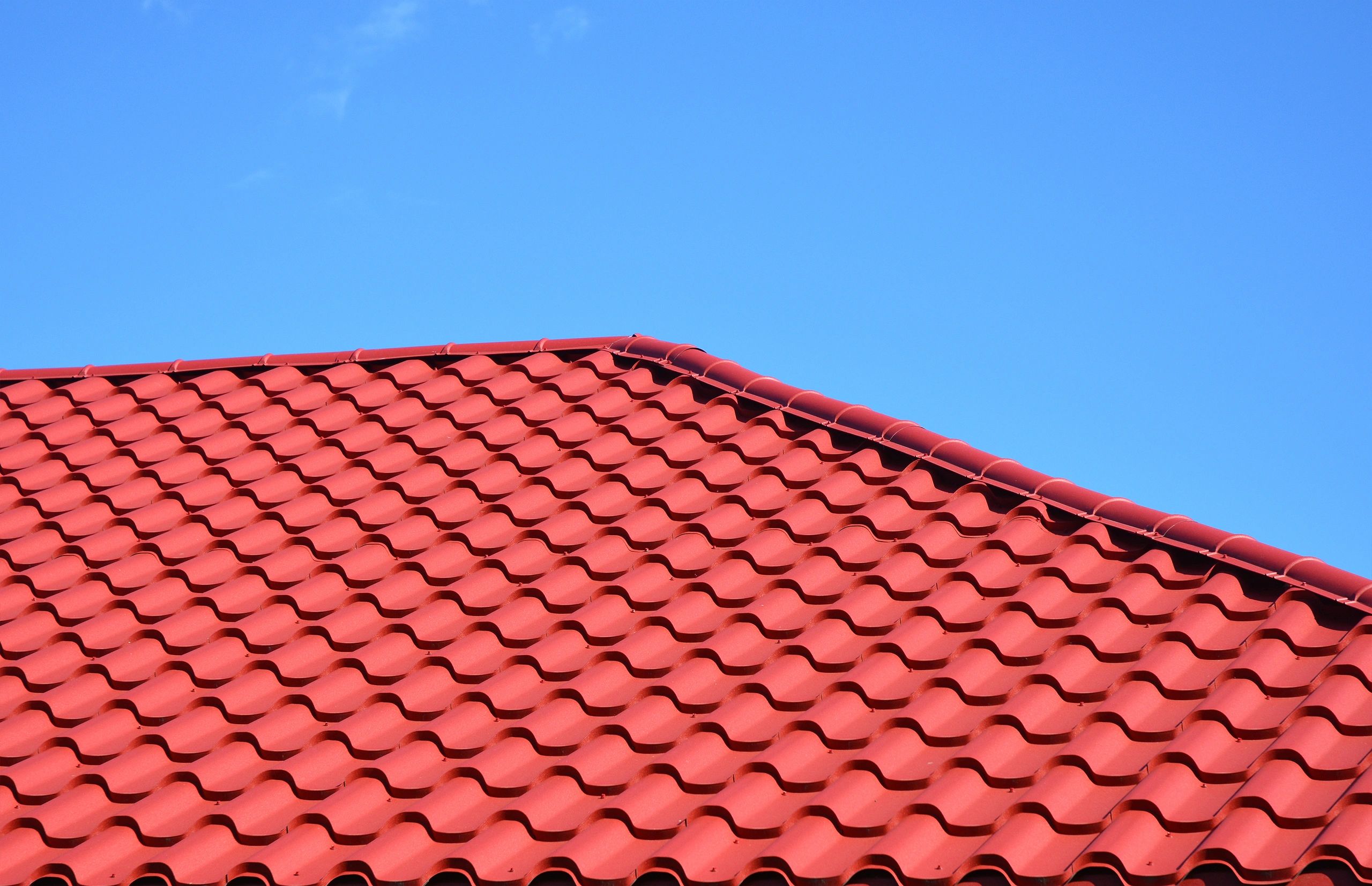 Worker is cleaning clogs in roof gutter drain