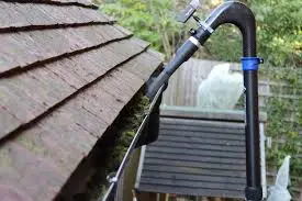 A gutter cleaning hose attached to the side of a house.